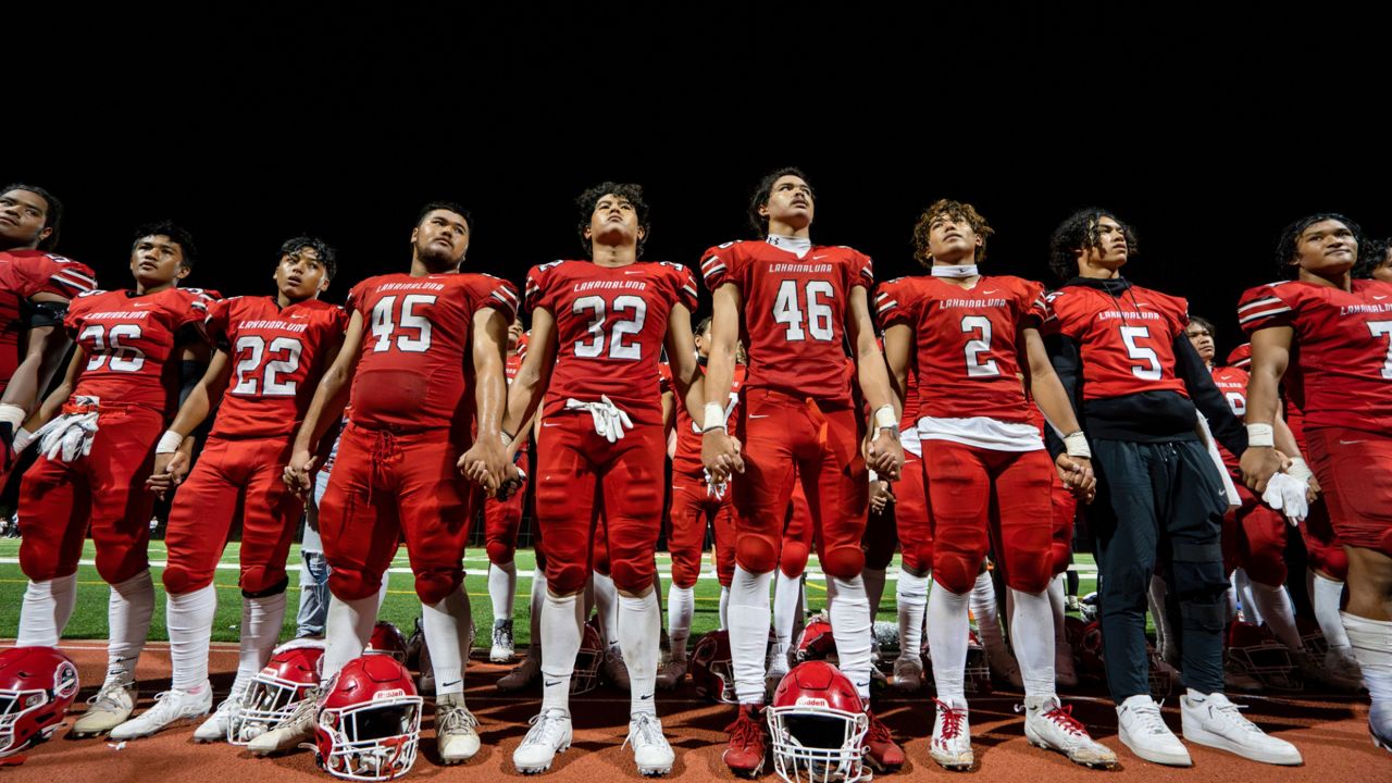 The Lahainaluna High School football team hold hands to thank the fans after a game Saturday, Oct. 21, 2023, in Lahaina, Hawaii. Captains of the team whose town was destroyed by a deadly wildfire are going to Super Bowl in Las Vegas as guests of the NFL. (AP Photo/Mengshin Lin, File)