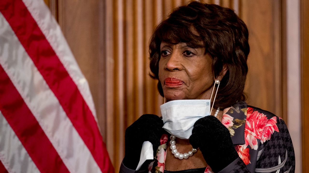 House Financial Services Committee Chairwoman Maxine Waters, takes her mask off to speak during a signing ceremony