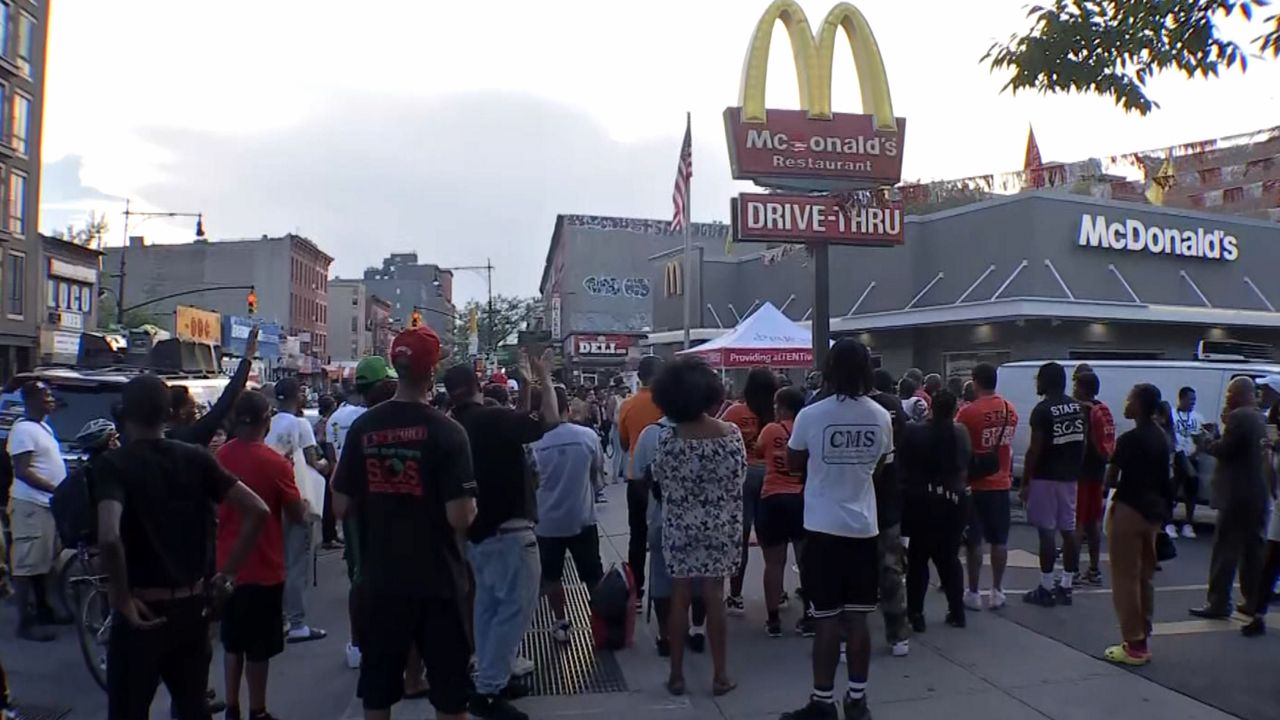 Dozens of community leaders gathered outside the McDonald’s in Bedford-Stuyvesant on Friday afternoon after a McDonald's worker was shot and killed. (NY1 Photo)