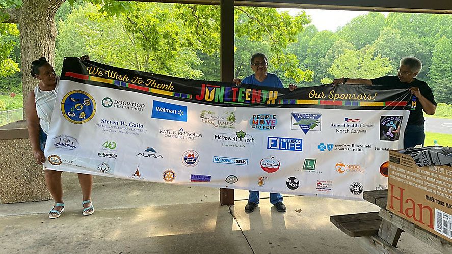 Organizers pose with Juneteenth banner. 