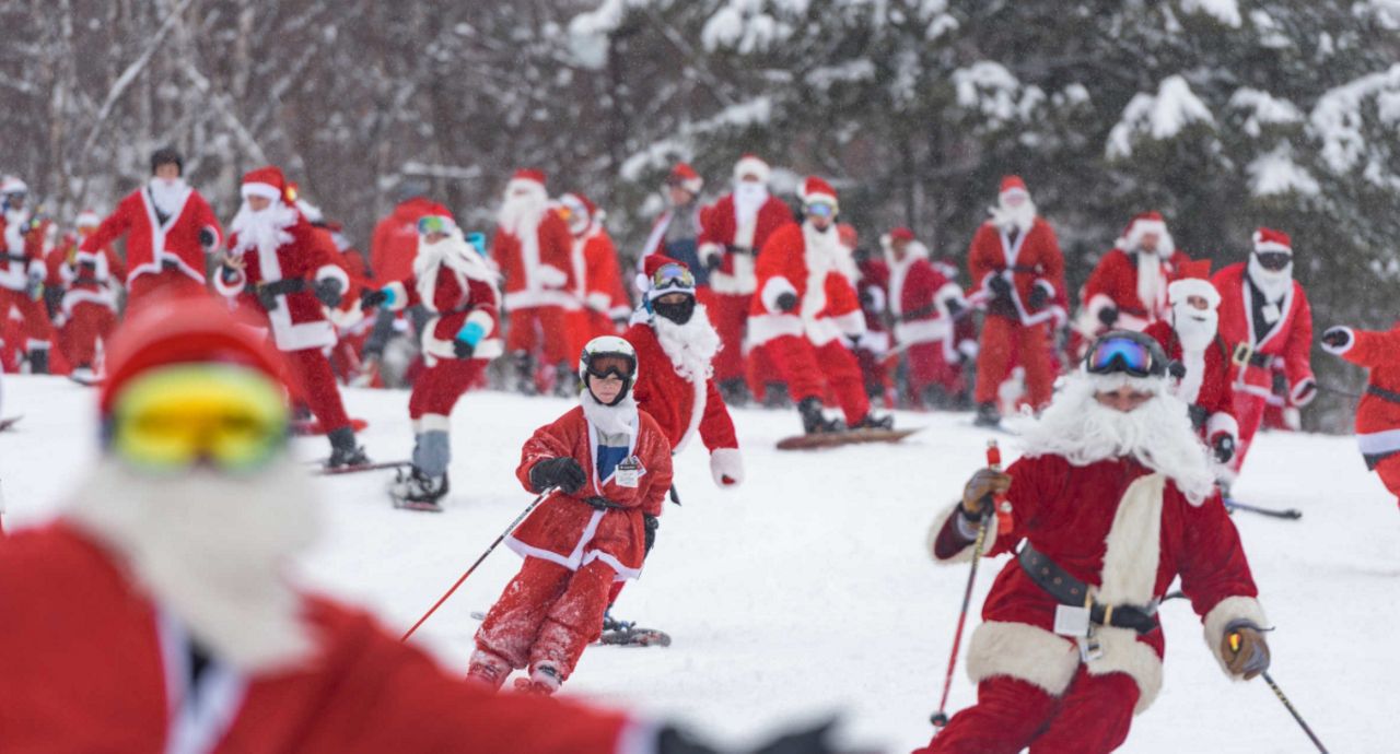 Skiers dressed as Santa take a run down the mountain at Sunday River during its annual Santa Sunday event. (Photo by Marina French via Sunday River)