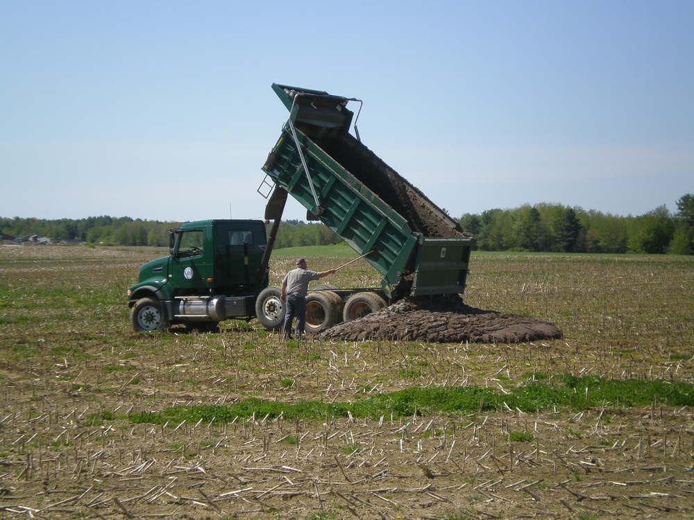 farmer spreads biosolids on field