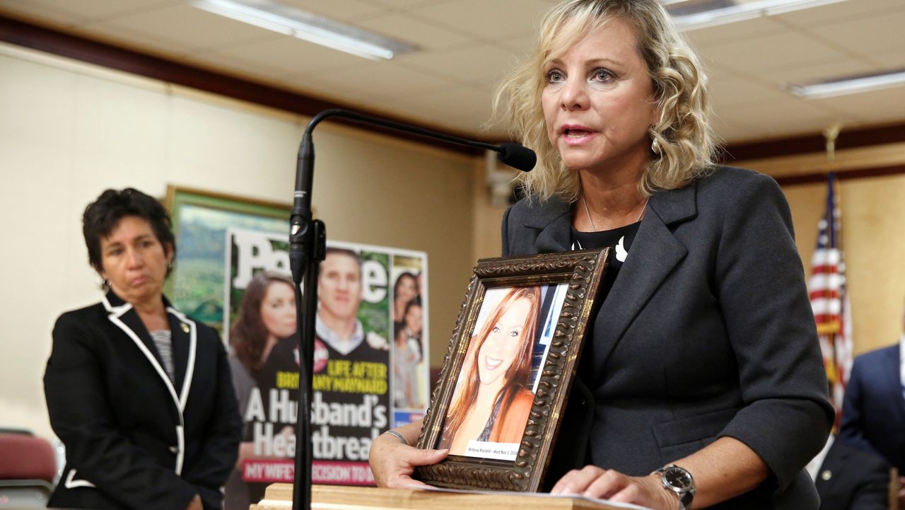 Debbie Ziegler holds a photo of her daughter, Brittany Maynard, the California woman with brain cancer who moved to Oregon to legally end her life, during a news conference to announce the reintroduction of right to die legislation, Tuesday, Aug. 18, 2015, in Sacramento, Calif. (AP Photo/Rich Pedroncelli, File)