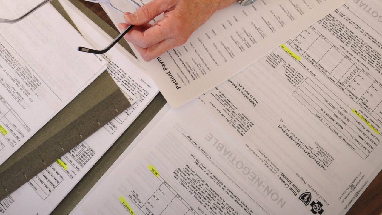 FILE - In this Dec. 20, 2011 file photo medical bills are spread out on the kitchen table of a cancer patient in Salem, Va. (AP Photo/Don Petersen, File)