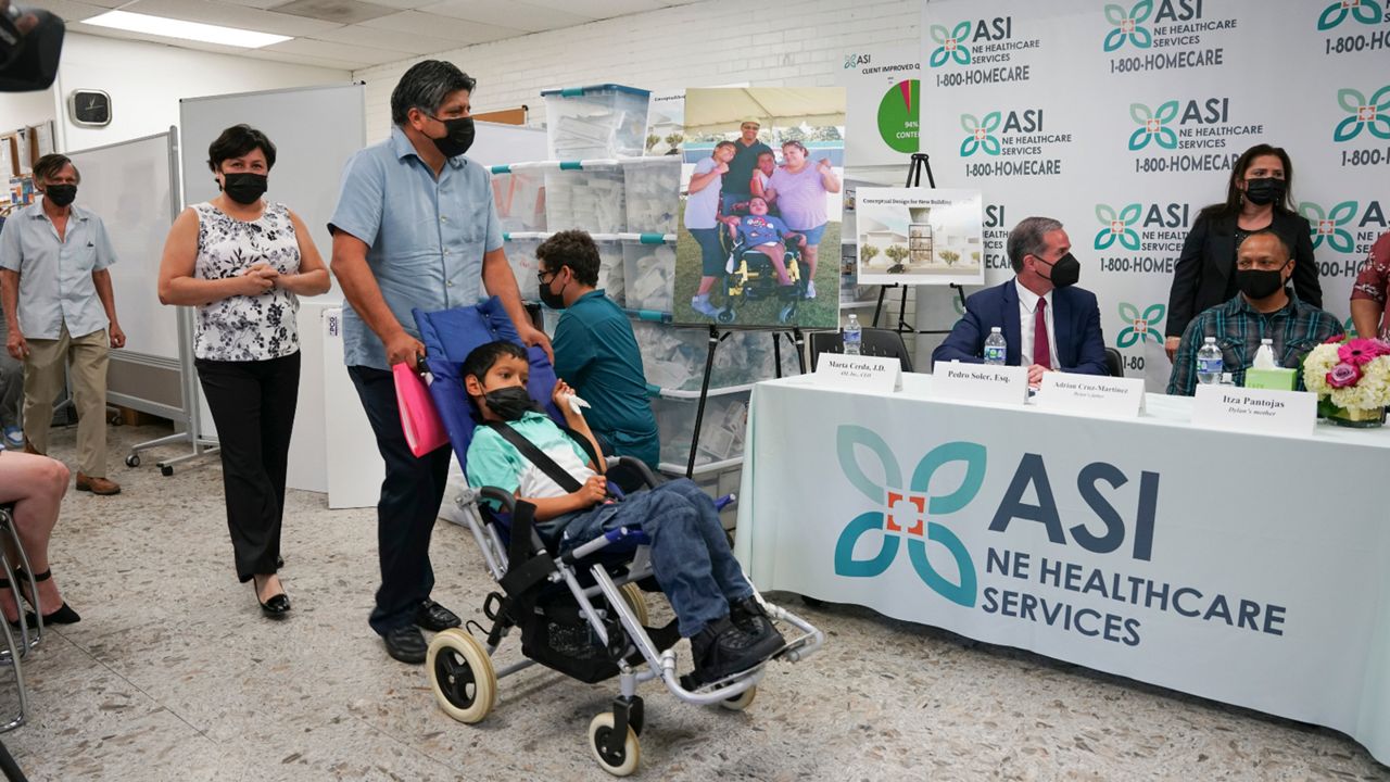 In this photo provided by Clifford Law Offices, Karina Aguilar, her husband, Temo Aguilar, and their son Felipe Aguilar attend a news conference on Aug. 3, 2021, at the office of ASI/NE Healthcare Services in Chicago. After Itza Pantoja's severely disabled son died at the age of 16, she made it her mission to ensure that the wheelchairs, beds and other equipment and supplies that had helped him got to others who needed them. Many of the items, including a car seat, standing chair and bed, went to Felipe Aguilar, a 12-year-old Chicago boy with cerebral palsy. (Clifford Law Offices, Chicago via AP)