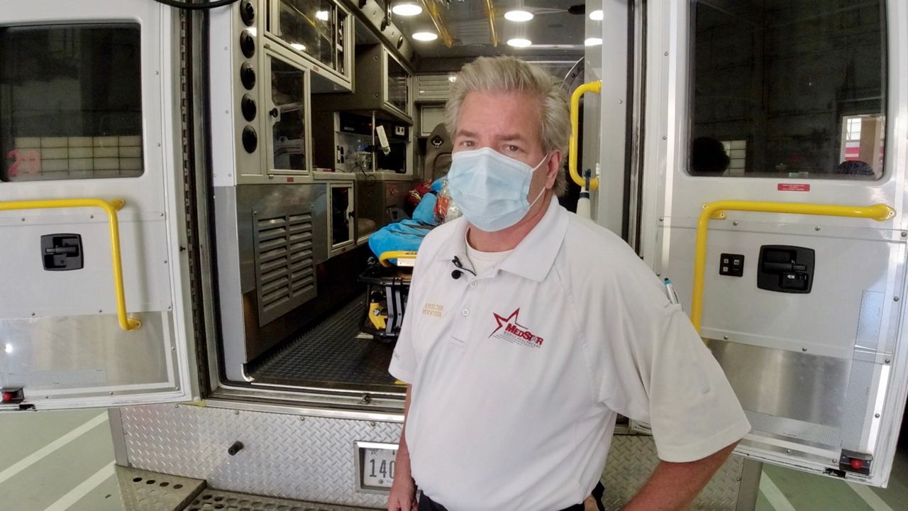 John Hamilton in front of a MedStar ambulance.