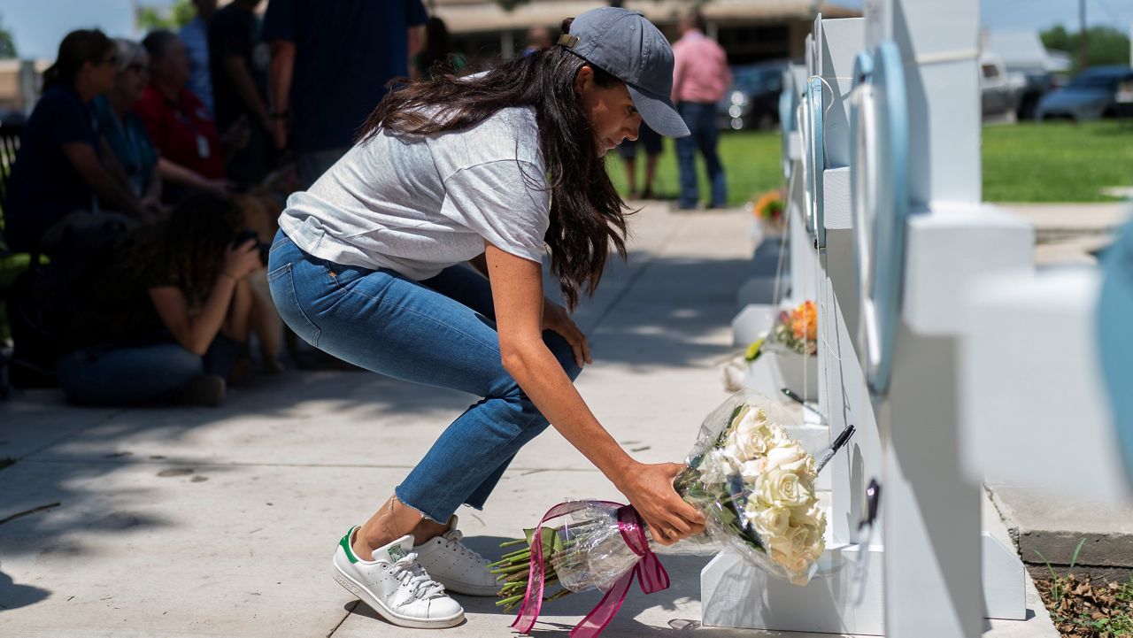 Meghan Markle, Duchess of Sussex, leaves flowers at a memorial site, Thursday, May 26, 2022, for the victims killed in this week's elementary school shooting in Uvalde, Texas. (AP Photo/Jae C. Hong)