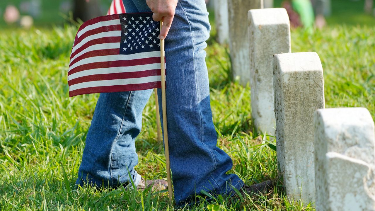An American flag placed in front of a gravestone. (Photo: AP)