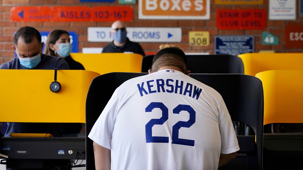 Los Angeles Dodgers fan Adam Tapia, 23, of Whittier, Calif., votes on Election Day at Dodger Stadium, Tuesday, Nov. 3, 2020, in Los Angeles. (AP Photo/Chris Pizzello)