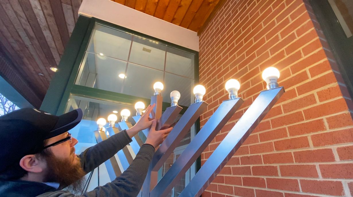 Levi Stein, the executive director of the Friendship Circle of Wisconsin, sets up a menorah in 2022. (Spectrum News/Katarina Velazquez)