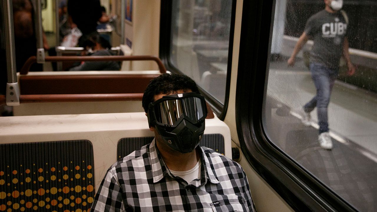 Ehab Hassanin wears a protective face mask while riding while riding a Metro Rail train Monday, July 6, 2020, in Los Angeles during the coronavirus pandemic. (AP Photo/Jae C. Hong)