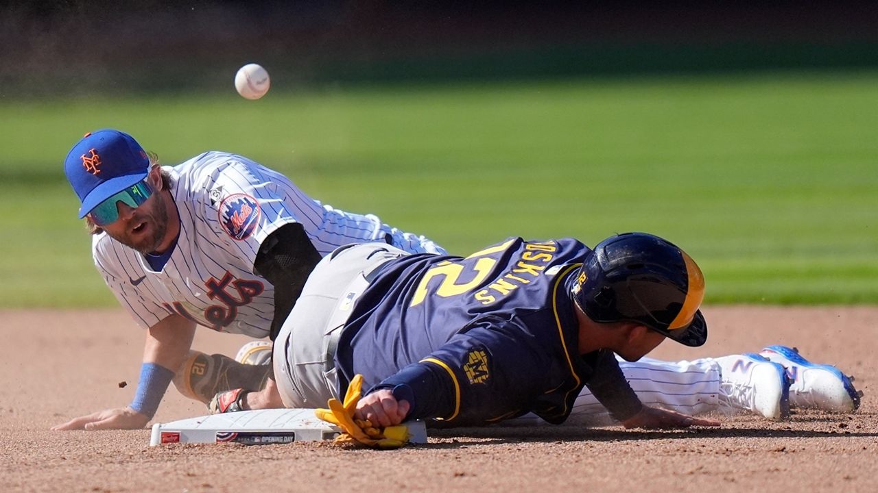 New York Mets' Jeff McNeil (1) loses control of the ball as Milwaukee Brewers' Rhys Hoskins (12) slides into him during the eighth inning of a baseball game Friday, March 29, 2024, in New York. (AP Photo/Frank Franklin II)