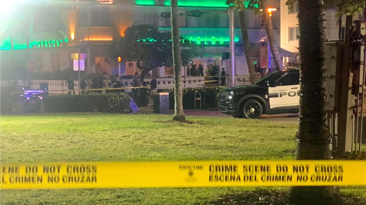 Crime scene tape is shown at the scene along Ocean Drive in Miami Beach, Fla. Friday, March 17, 2023, where police say one person was killed and a second was wounded when gunfire erupted in an area of Miami Beach crowded with people on spring break. (Aaron Leibowitz/Miami Herald via AP)