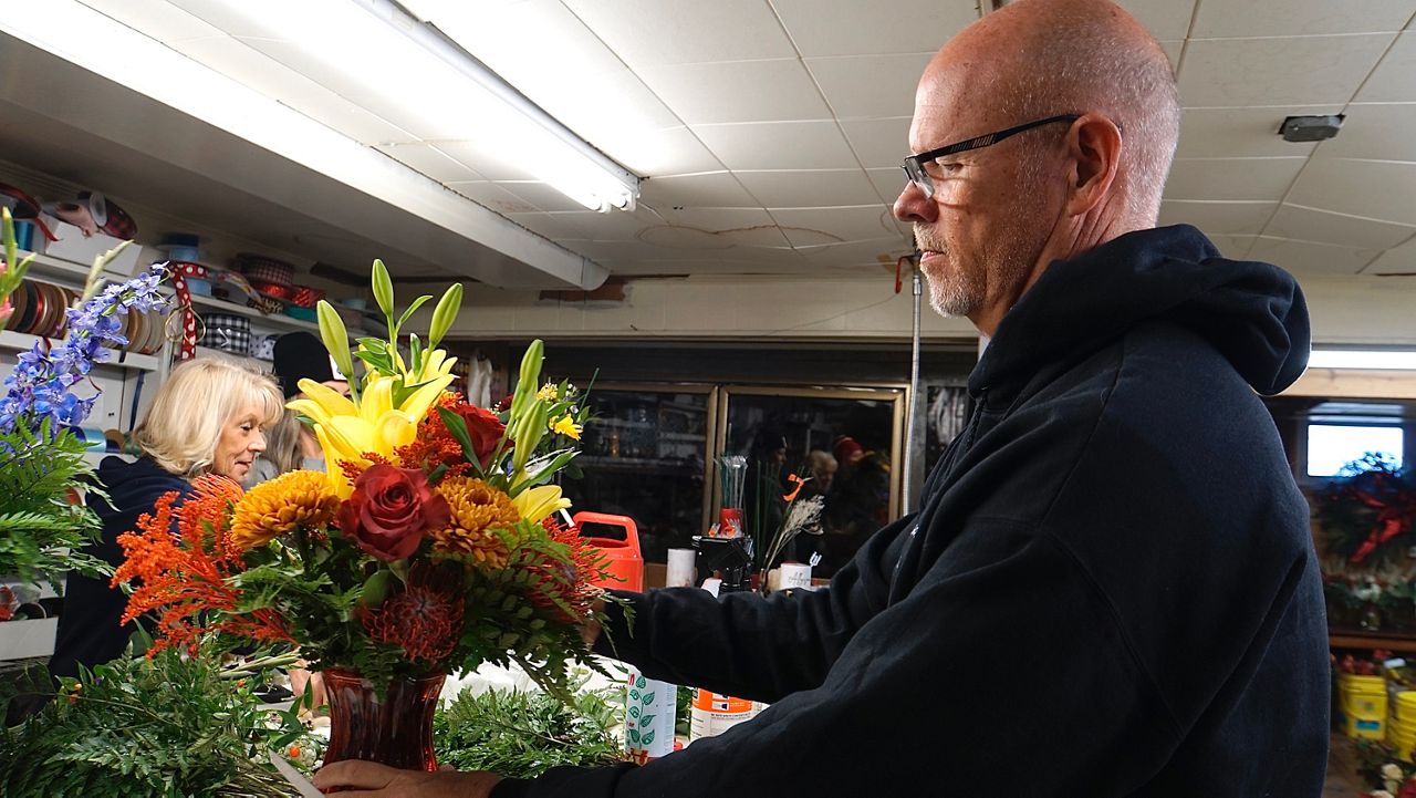 Michael Gaddie, owner of Lloyd’s Florist, prepares a bouquet for an upcoming event (Spectrum News 1/Mason Brighton)