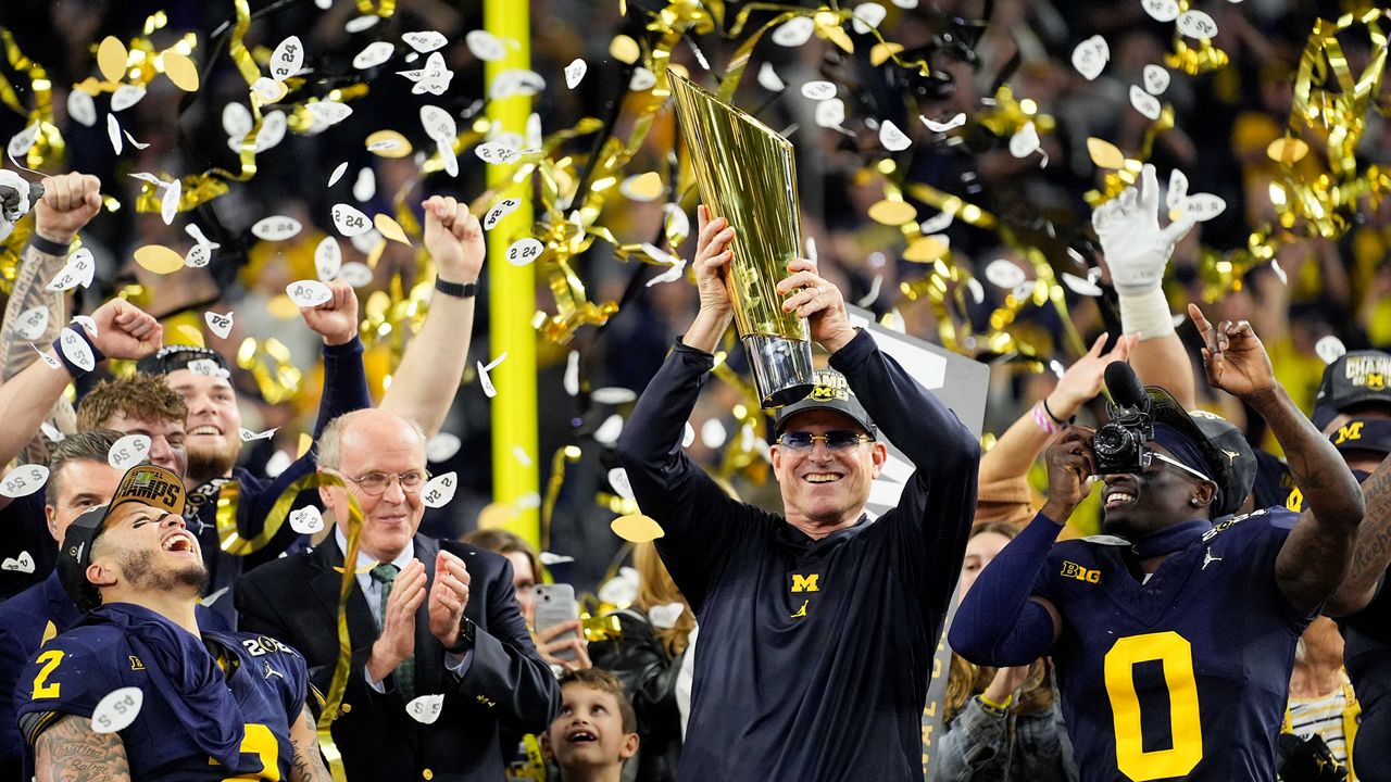 Coach Jim Harbaugh and the Michigan Wolverines celebrate with the trophy after their win in the College Football Playoff national championship game against Washington on Monday, Jan. 8, 2024, in Houston. (AP Photo/Eric Gay)