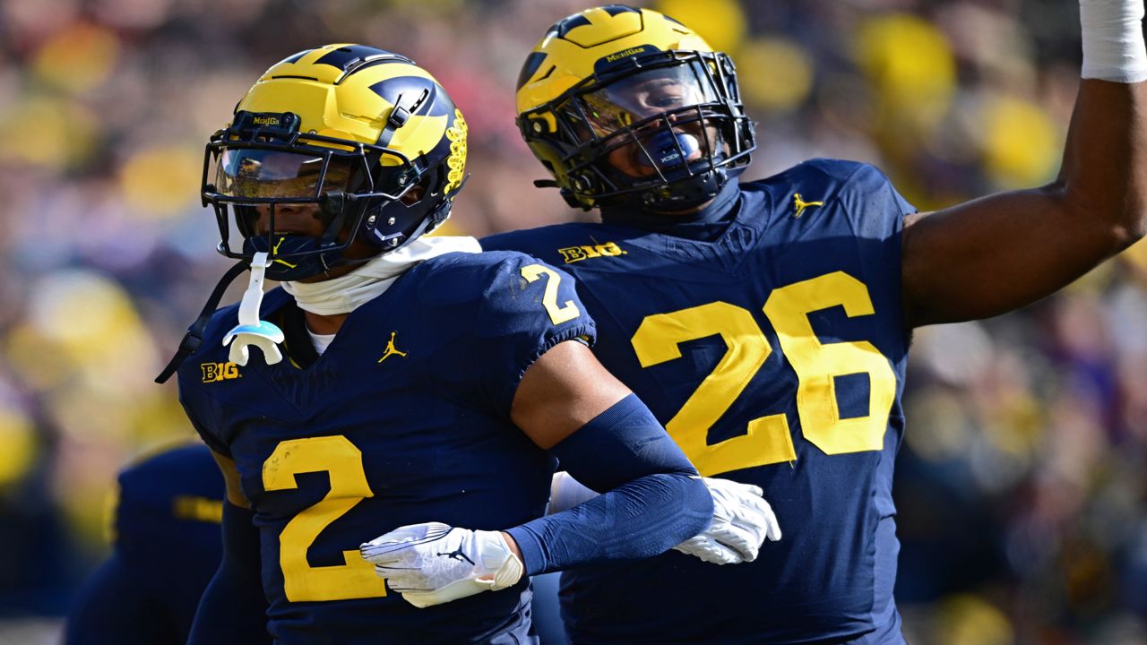 Michigan defensive back Will Johnson, left, celebrates with defensive lineman Rayshaun Benny after intercepting a pass during the first half of an NCAA college football game against Ohio State, Saturday, Nov. 25, 2023, in Ann Arbor, Michigan.