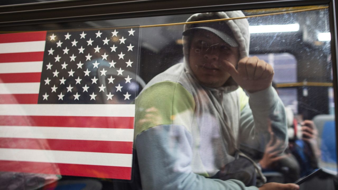Asylum seekers are seen inside of a bus outside the Roosevelt Hotel on Friday, May 19, 2023, in New York. The historic hotel in midtown Manhattan shuttered three years ago, will accommodate an anticipated influx of asylum seekers just as other New York City hotels are being converted to emergency shelters. (AP Photo/Eduardo Munoz Alvarez)
