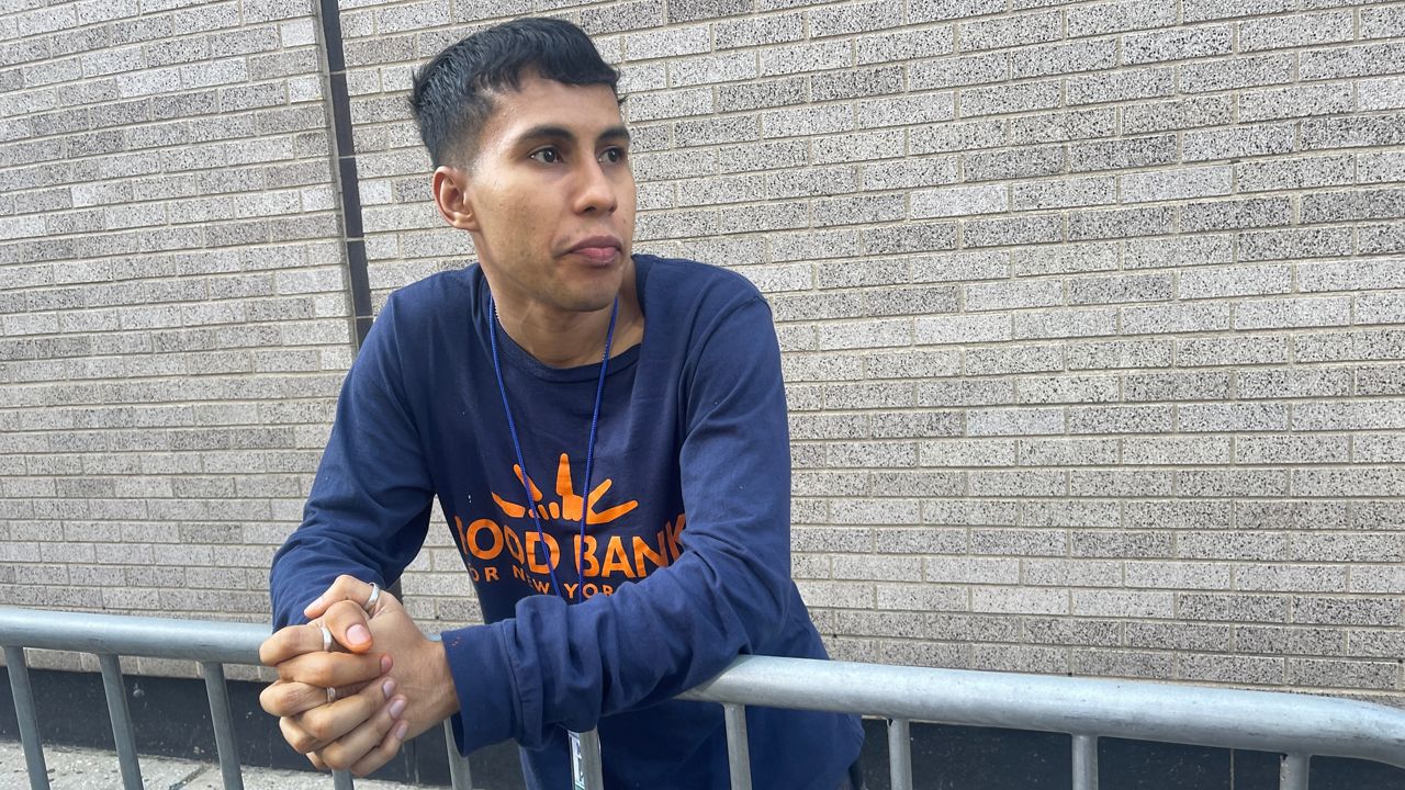 Alan Cardenas is pictured in a blue and orange shirt.