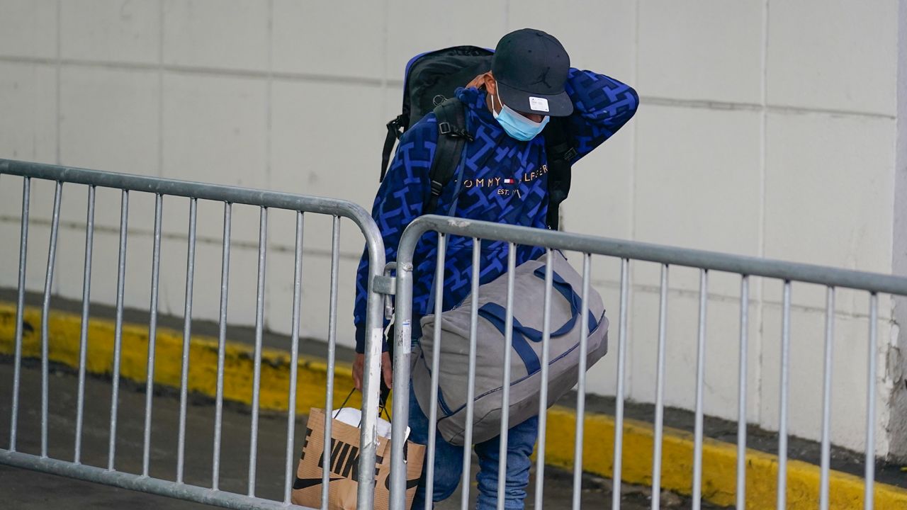 A man carrying his belongings leaves the Watson Hotel in New York on Monday, Jan. 30, 2023.