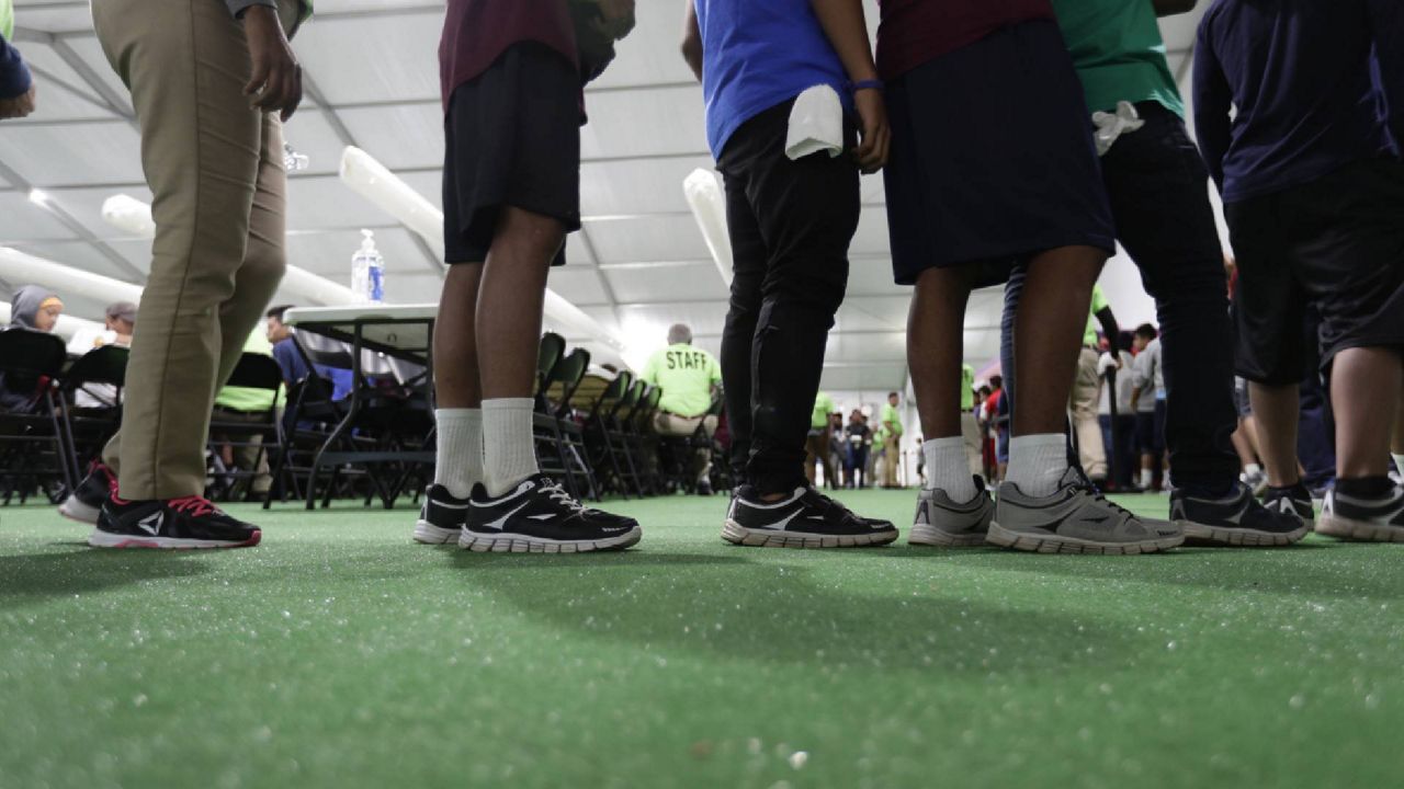 FILE - In this July 9, 2019, file photo, immigrants line up in the dinning hall at the U.S. government's newest holding center for migrant children in Carrizo Springs, Texas. (AP Photo/Eric Gay, File)