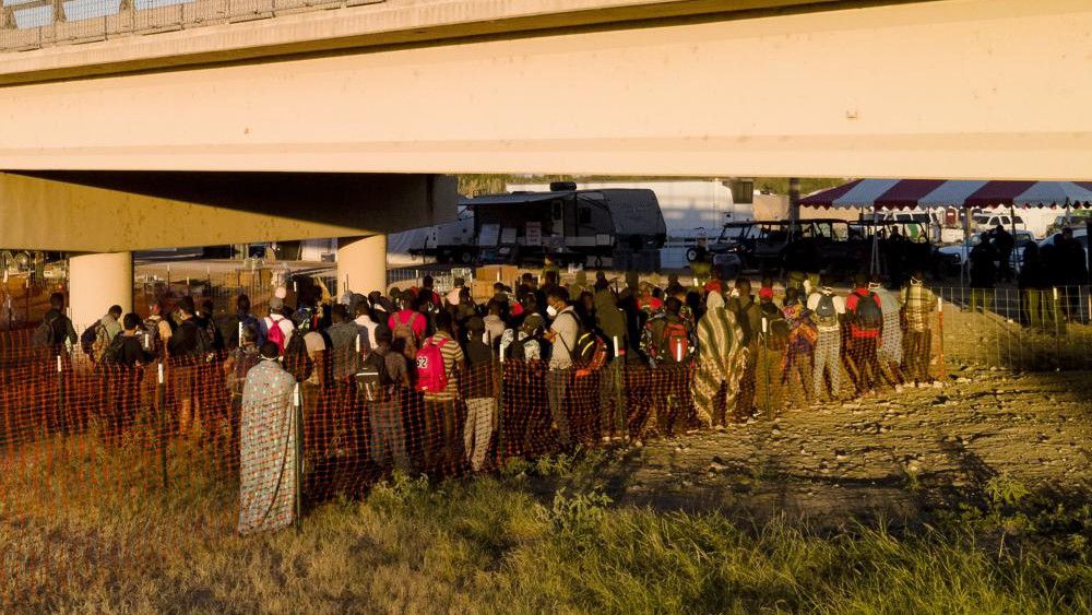 Migrants, many from Haiti, wait in lines to board buses under the Del Rio International Bridge, Friday, Sept. 24, 2021, in Del Rio, Texas. (AP Photo/Julio Cortez)