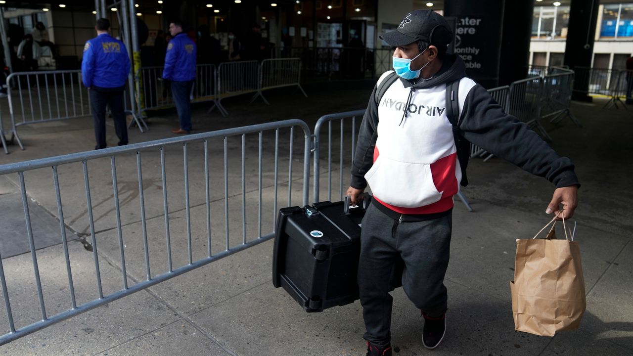 A man carrying his belongings leaves the Watson Hotel in New York, Monday, Jan. 30, 2023. Recent immigrants to New York City, mostly from Venezuela and other Latin American countries, had been living in the hotel until recently, when they were told to leave the temporary shelter. 