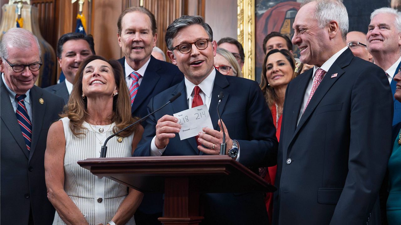 House Speaker Mike Johnson, R-La., flanked by Rep. Lisa McClain, R-Mich., left, and Majority Leader Steve Scalise, R-La., right, holds the vote tally sheet as he celebrates with fellow Republicans after final passage of President Donald Trump's signature bill of tax breaks and spending cuts, at the Capitol in Washington, Thursday, July 3, 2025. (AP Photo/J. Scott Applewhite)