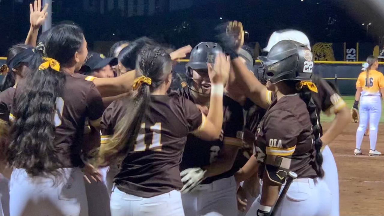 Mililani players slapped the helmet of pitcher Dani Monroe (21), center, after her three-run home run against Leilehua in the bottom of the second inning at McKinley on Tuesday.