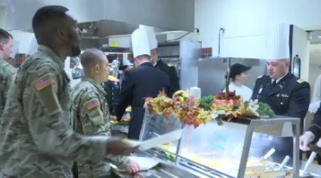 Military men line up to receive Thanksgiving meal.