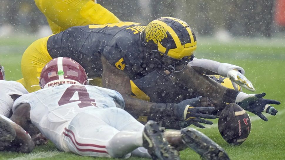 Michigan defensive end Derrick Moore (8) recovers a fumble by Alabama quarterback Jalen Milroe (4) during the first half of the ReliaQuest Bowl NCAA college football game Tuesday, Dec. 31, 2024, in Tampa, Fla. (AP Photo/Chris O'Meara)