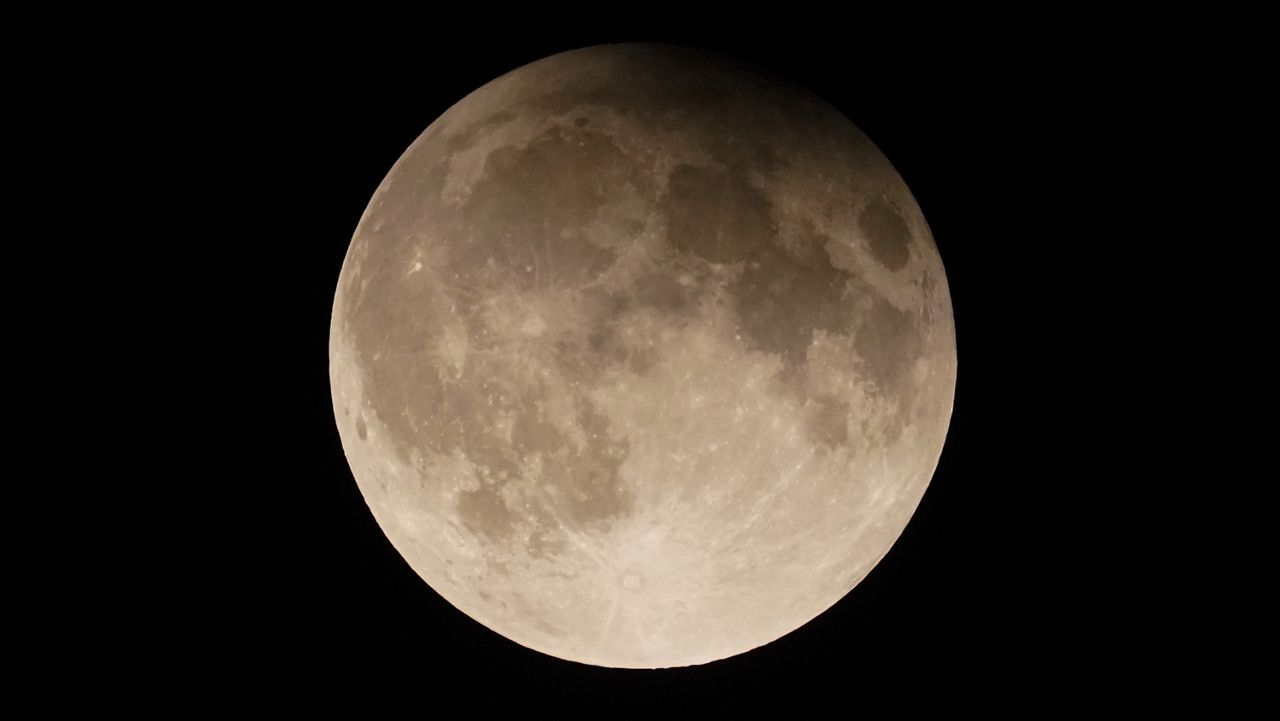 A supermoon with a partial lunar eclipse rises over Lake Michigan in Chicago, Tuesday, Sept. 17, 2024. (AP Photo/Kiichiro Sato, File)