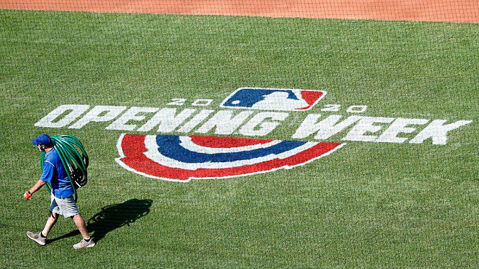 A groundskeeper walks past the 2020 Opening Week sign painted on the field before the start of a New York Mets intrasquad baseball game at Citi Field, Wednesday, July 22, 2020, in New York. (AP Photo/Kathy Willens)