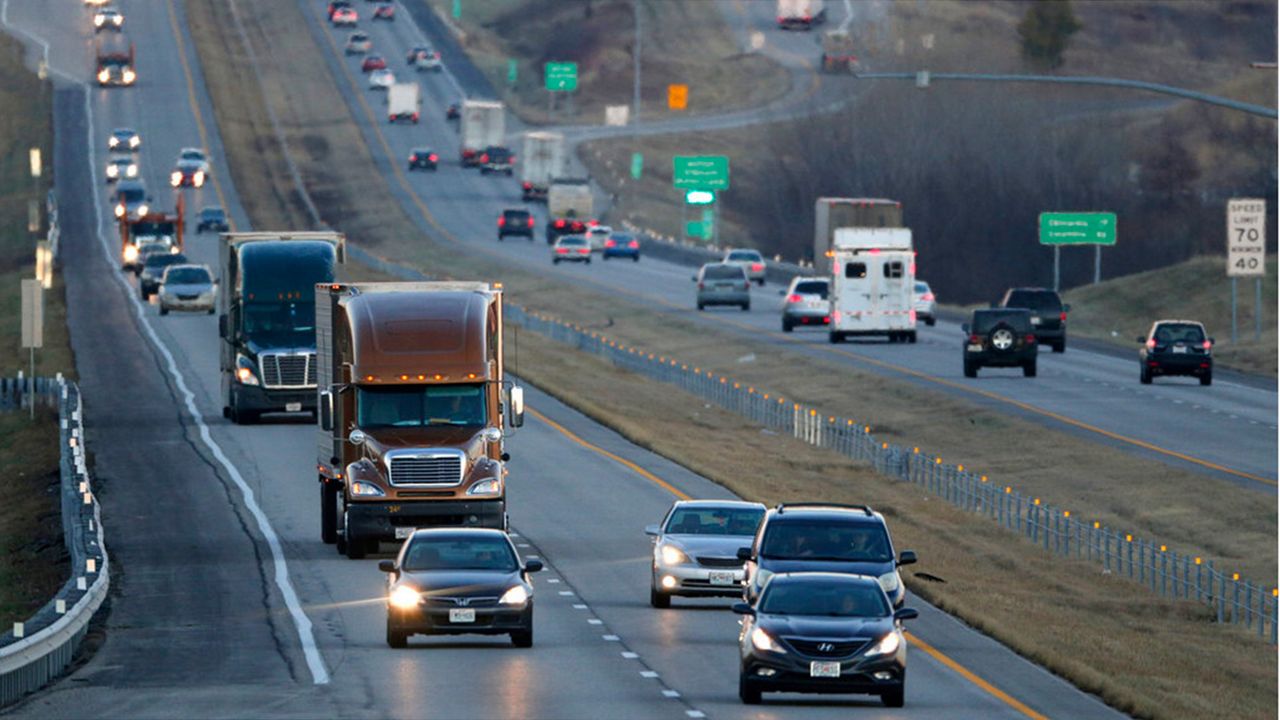 In this Jan. 14, 2016, file photo, vehicles travel along Interstate 70 near Odessa, Mo. Suddenly road trips are trendy again. (AP Photo/Charlie Riedel)