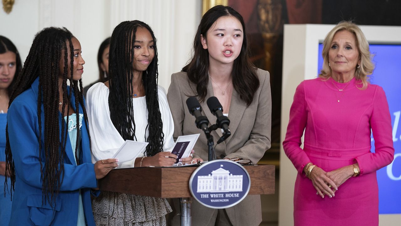 Mona Cho, of Redondo Beach, Calif., speaks during a "Girls Leading Change" event to honor International Day of the Girl, in the East Room of the White House, Wednesday, Oct. 11, 2023, in Washington. From left, Breanna and Brooke Bennett, of Montgomery, Ala., Cho, and first lady Jill Biden. (AP Photo/Evan Vucci)