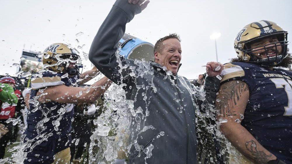 Montana State head coach Brent Vigen gets a cooler of water dumped on him after an NCAA college football game in the semifinals of the FCS playoffs, Saturday, Dec. 18, 2021, in Bozeman, Mont. Montana State beat South Dakota State 31-17. (AP Photo/Tommy Martino)