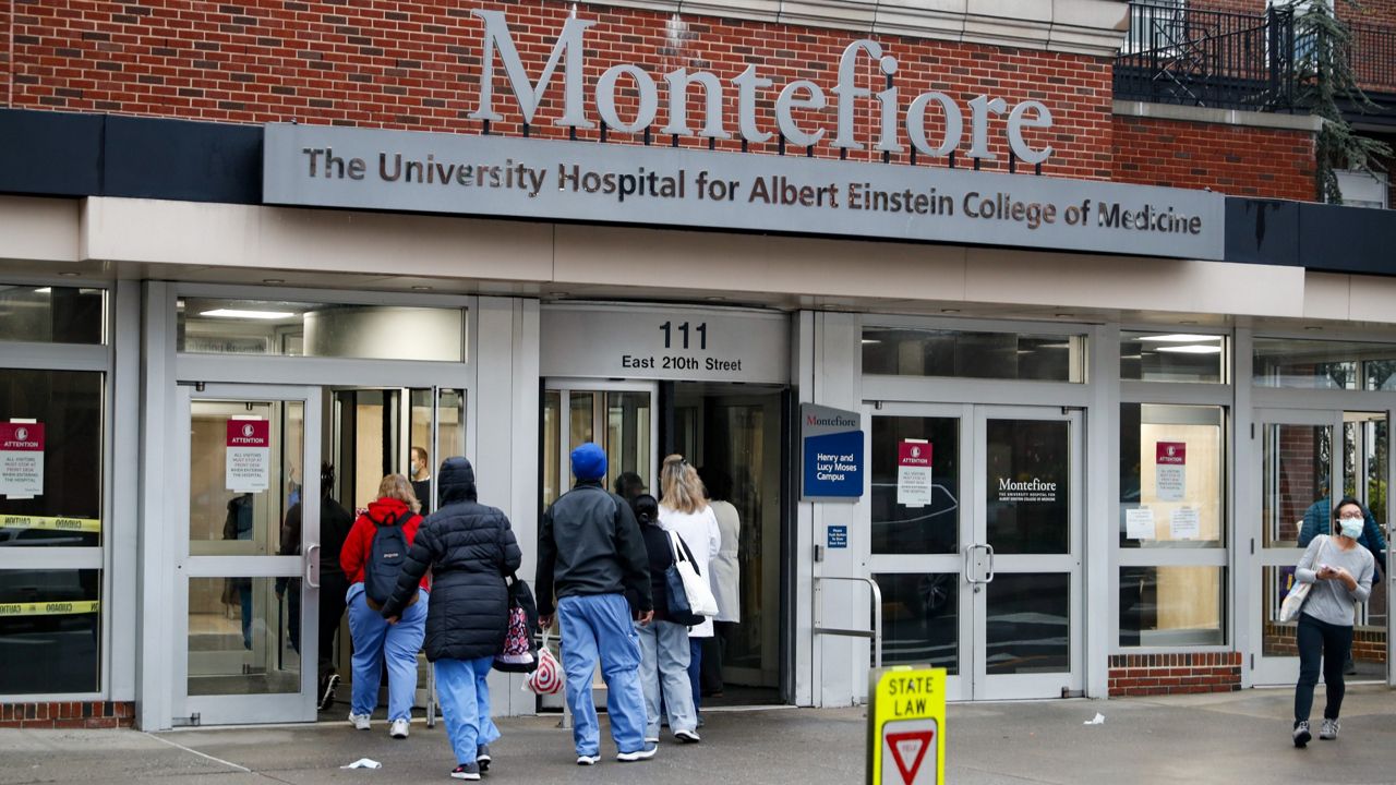 Medical workers enter Montefiore Medical Center during the coronavirus pandemic, Friday, April 24, 2020, in the Bronx borough of New York. Negotiations to keep 10,000 New York City nurses from walking off the job headed Friday, Jna. 6, 2023, into a final weekend as some major hospitals braced for a potential strike by sending ambulances elsewhere and transferring such patients as vulnerable newborns. (AP Photo/John Minchillo, File)