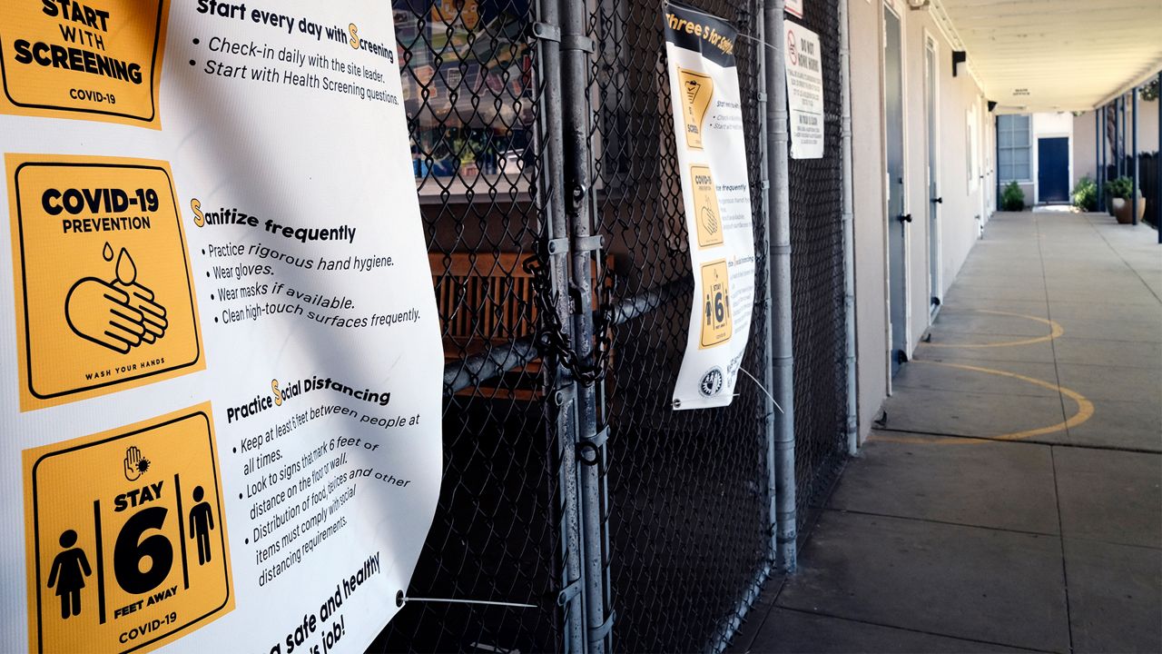 A chain-link fence lock is seen on a gate at a closed Ranchito Elementary School in the San Fernando Valley section of Los Angeles on Monday, July 13, 2020. Amid spiking coronavirus cases, Los Angeles Unified School District campuses will remain closed when classes resume in August, Superintendent Austin Beutner said Monday. (AP Photo/Richard Vogel)