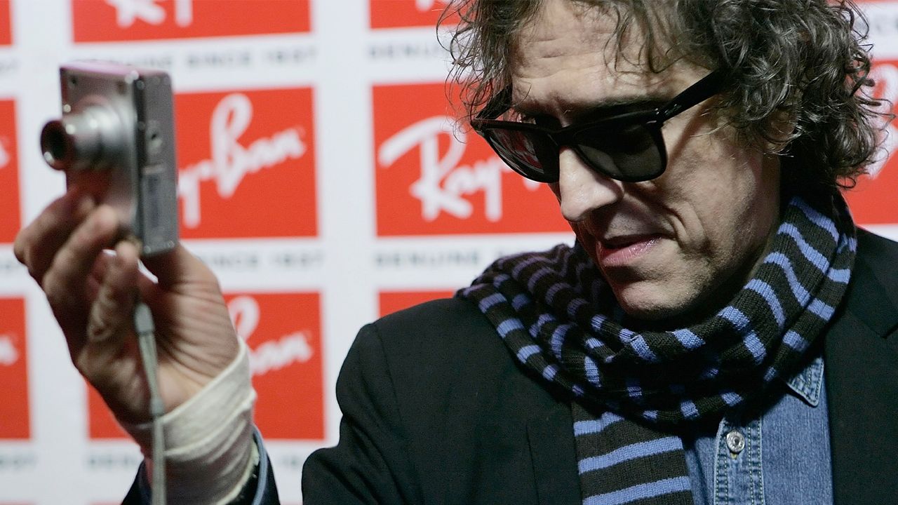 Photographer Mick Rock uses a point and shoot camera to photographer the photographers at the Uncut Ray-Ban Wayfarer Sessions event, on Nov. 15, 2006 at Irving Plaza in New York. (AP Photo)