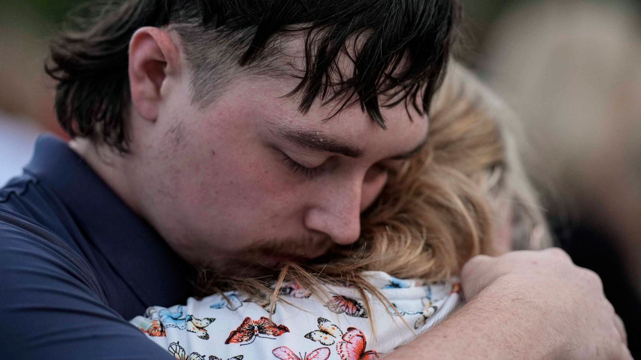 Mourners pray during a candlelight vigil for the slain students and teachers at Apalachee High School, Wednesday, Sept. 4, 2024, in Winder, Ga.