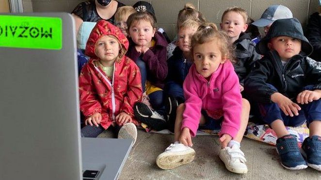 kids sit in front of a laptop for storytime