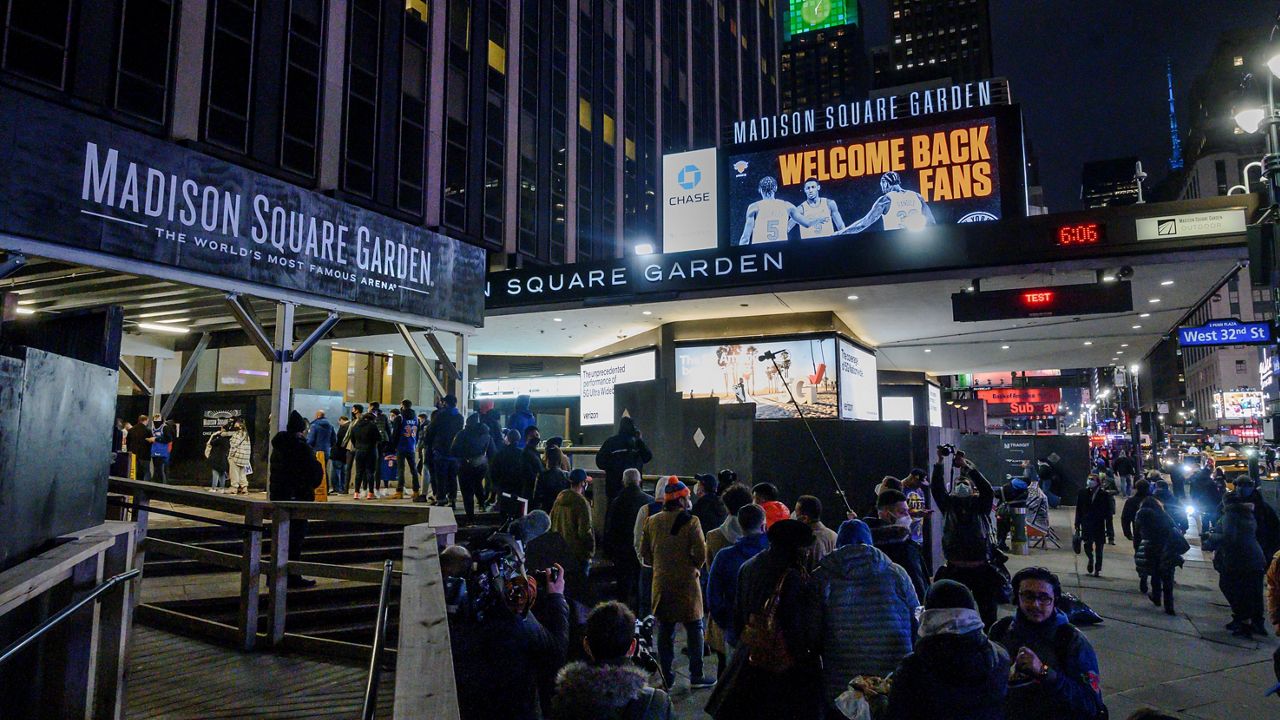 Fans line up outside Madison Square Garden for an NBA basketball game between the New York Knicks and the Golden State Warriors in New York, Tuesday, Feb. 23, 2021. (AP Photo/Brittainy Newman, File)