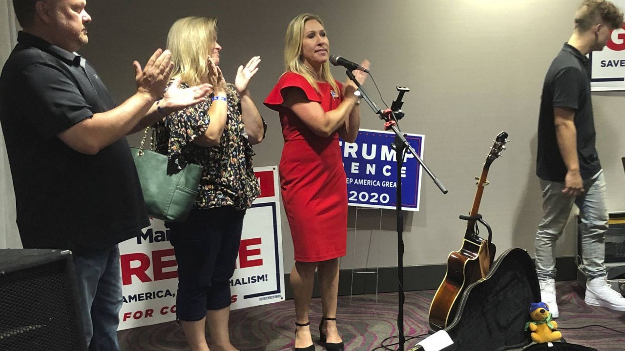 Marjorie Taylor Greene claps with her supporters at a watch party event (via Associated Press)