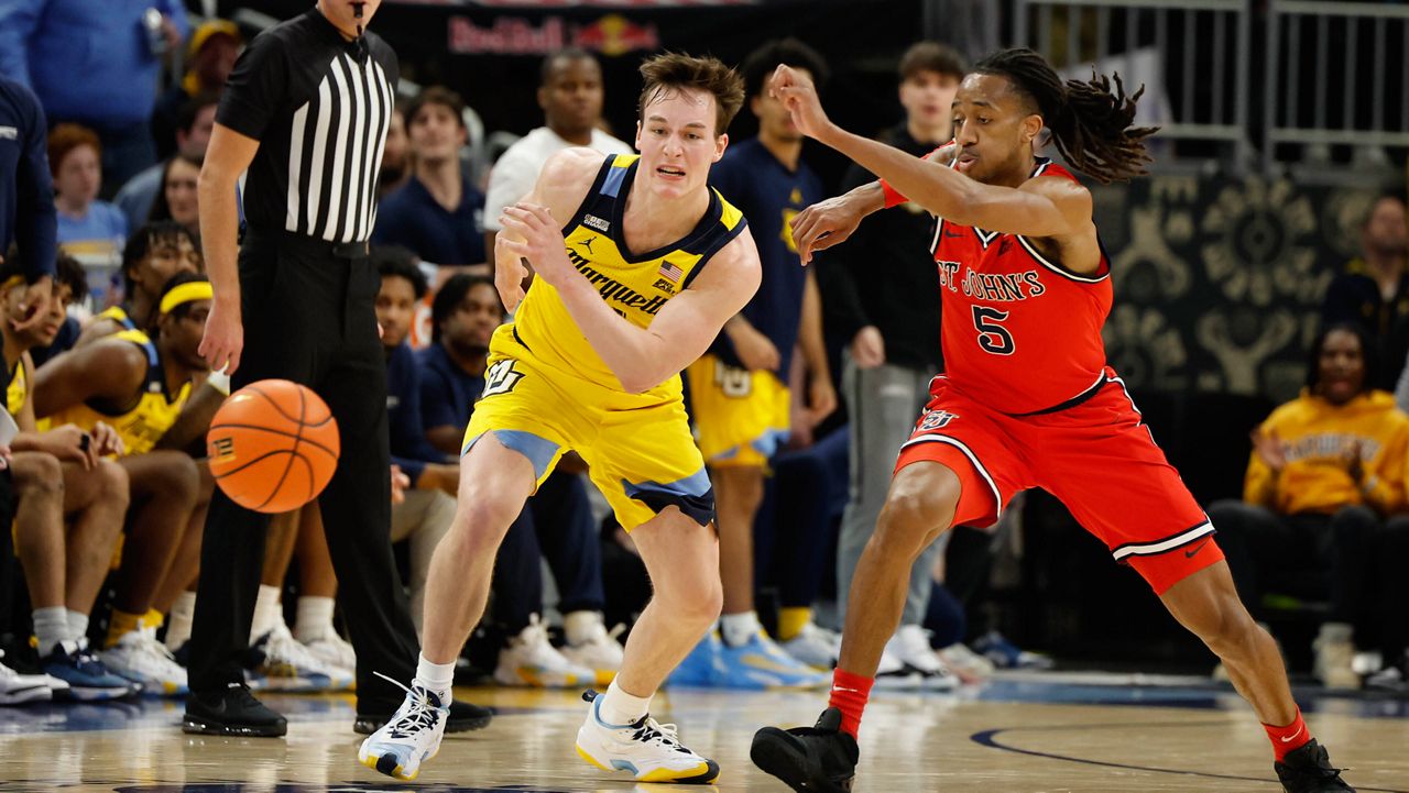 Marquette's Tyler Kolek (11) and St. John's RJ Luis Jr. 5) chase the ball during the second half of an NCAA college basketball game Saturday, Feb. 10, 2024, in Milwaukee. (AP Photo/Jeffrey Phelps)