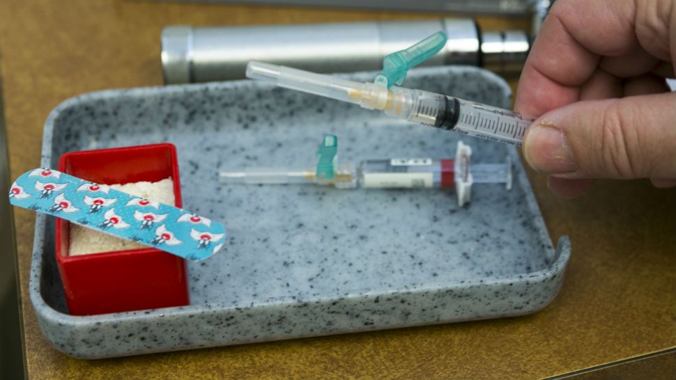In this Thursday, Jan. 29, 2015, photo, a single-dose of the measles-mumps-rubella virus vaccine live, or MMR vaccine is ready at the practice of Dr. Charles Goodman in Northridge, Calif. The measles-mumps-rubella vaccine, or MMR, is 99 percent effective at preventing measles, which spreads easily through the air and in enclosed spaces. Symptoms include fever, runny nose, cough and a rash all over the body. (AP Photo/Damian Dovarganes)