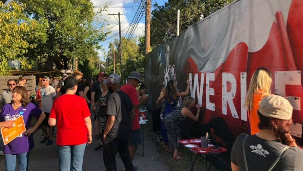 Members of the East Austin community work to restore a mural of U.S. Senate candidate Beto O'Rourke in this image from October 2018. (Allison Baron)