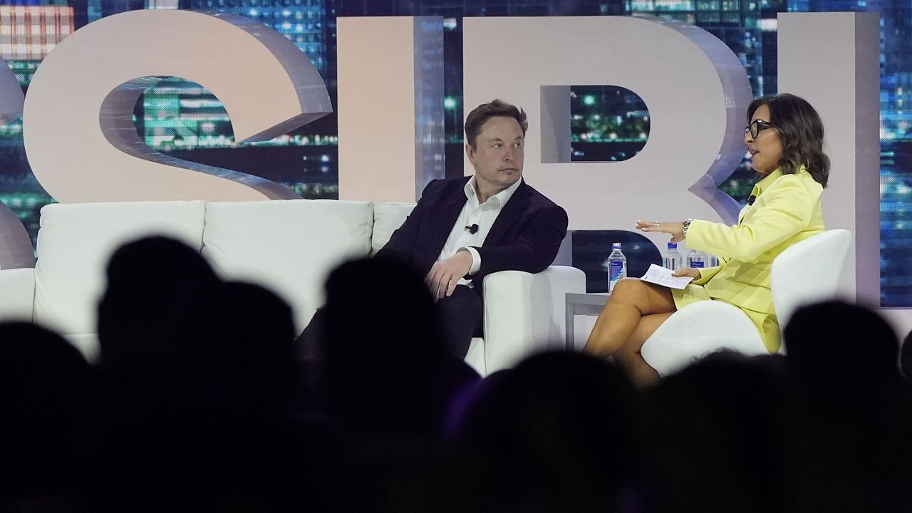 Twitter CEO Elon Musk, center, speaks with Linda Yaccarino, chairman of global advertising and partnerships for NBC, at the Possible marketing conference on April 18 in Miami Beach, Fla. (AP Photo/Rebecca Blackwell)