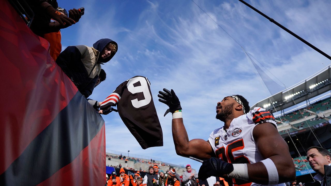 Cleveland Browns defensive end Myles Garrett (95) tosses a jersey to a fan after signing it before an NFL football game against the Cincinnati Bengals, Sunday, Dec. 22, 2024, in Cincinnati. (AP Photo/Joshua A. Bickel)