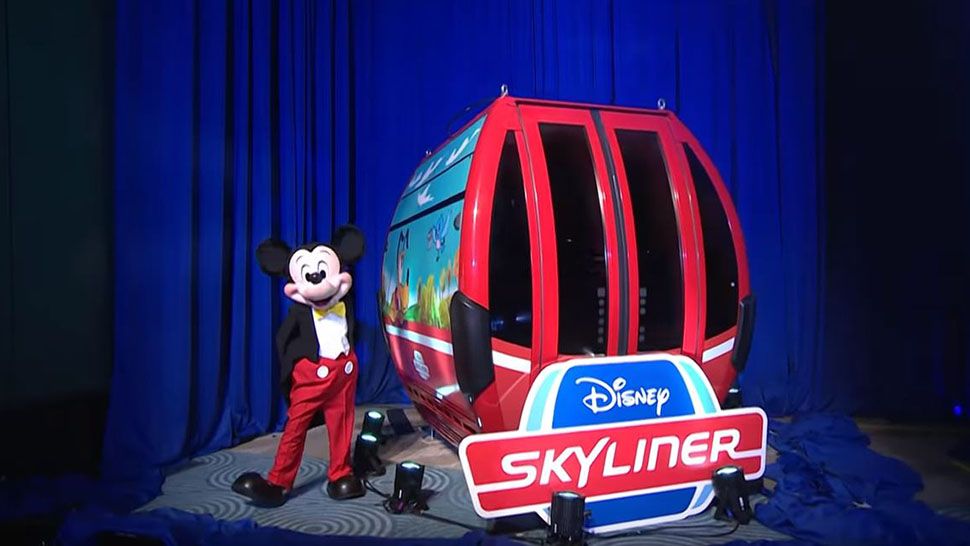 Mickey Mouse standing next to one of the Disney Skyliner gondolas at a Destination D event. (Courtesy of Disney)