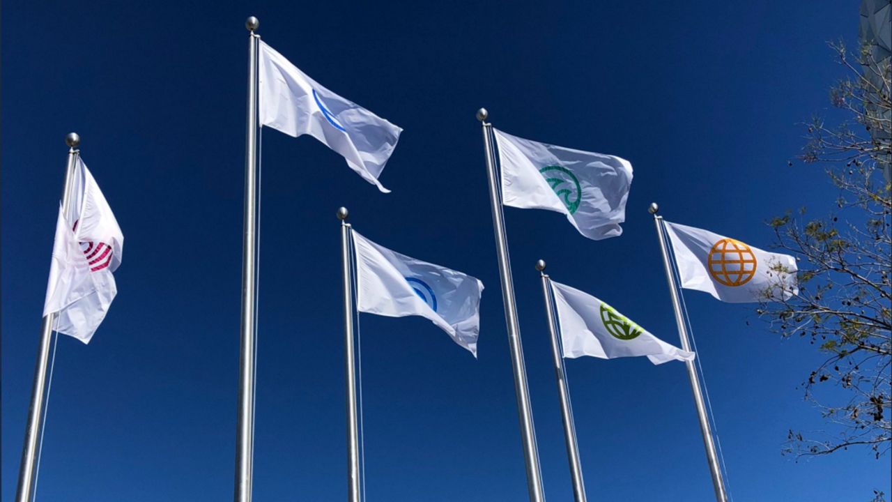 New flags flying at Epcot feature the park's original six icons. (Ashley Carter/Spectrum News)