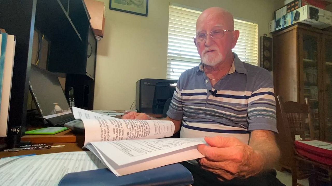 Joe Harris looks over his homeowner's insurance premium. Living off a fixed income, Harris said his homeowner’s insurance last year came in at $5,000. His 2023 renewal was going to be twice that — more than $10,000. (Spectrum News 13/Greg Pallone)